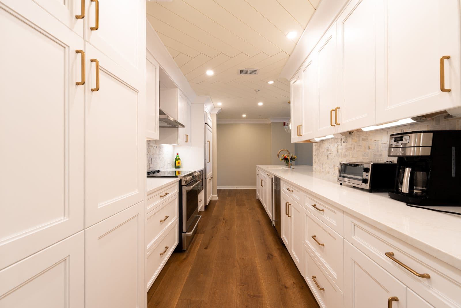 Renovated kitchen with white cabinetry and wood flooring